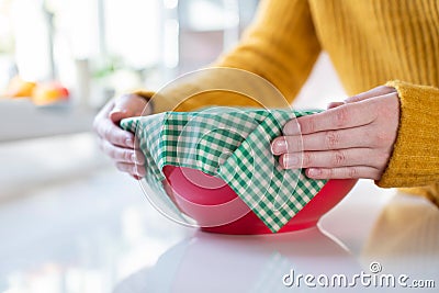 Close Up Of Woman Wrapping Food Bowl In Reusable Environmentally Friendly Beeswax Wrap Stock Photo