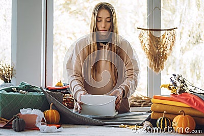 Woman wraps Furoshiki gift in zero waste style. Furoshiki Japanese Gift Wrapping. Thanksgiving Zero waste, eco-friendly Stock Photo