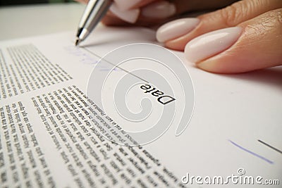 Woman writes date above line after signing contract papers Stock Photo