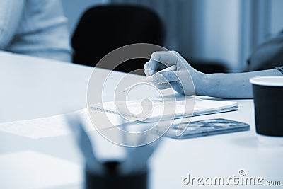 woman writes in a notebook at a meeting of colleagues in the corporate boardroom Stock Photo