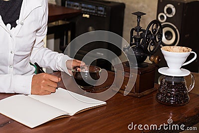 Woman writes a noteped on a wooden table. Stock Photo