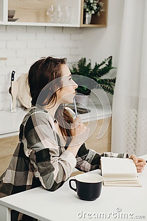 Woman writing in diary drinking morning coffee Stock Photo