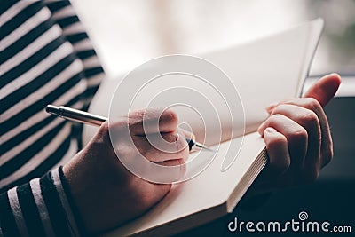 Woman writing diary by the window Stock Photo