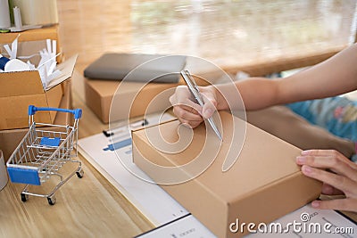 Woman is writing down the customer's details and addresses on the notebook Stock Photo