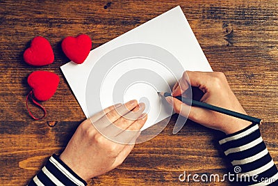 Woman writing love letter for Valentines day Stock Photo