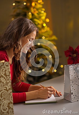 Woman writing in notebook list of purchasings Stock Photo