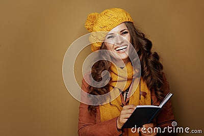 Woman writing personal goals in notebook on beige background Stock Photo