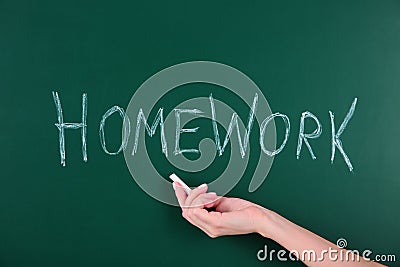 Woman writing word HOMEWORK on chalkboard, closeup Stock Photo