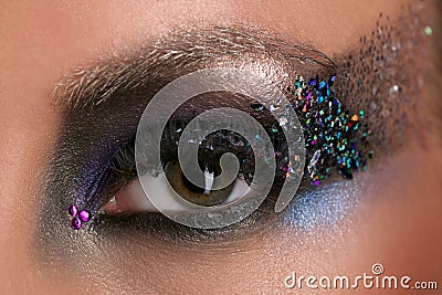Woman's eye with makeup and colorful crystals. Close up Stock Photo