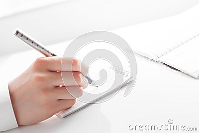 Woman's hand writing entries in a notebook Stock Photo