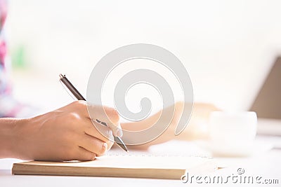 Woman's hand writing in notepad Stock Photo