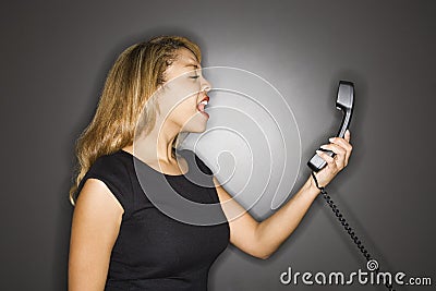 Woman yelling into telephone. Stock Photo