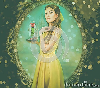 Woman in the yellow dress with red rose in her hands on the background of the mirror and the castle. Beauty and the beast cosplay Stock Photo