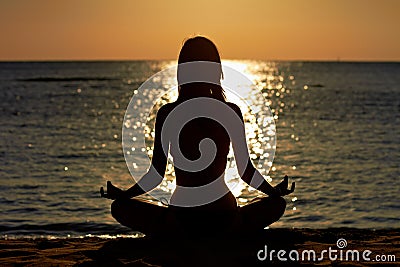 Woman in yoga lotus meditation at seaside Stock Photo
