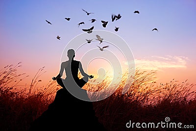 Woman yoga and meditating, silhouette on nature sunset Stock Photo
