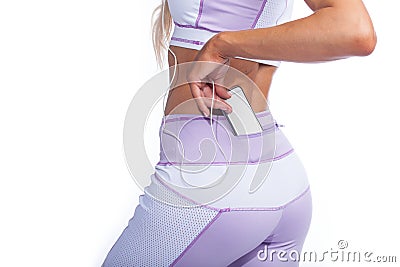 Woman in yoga pants with music player in pocket back view Stock Photo