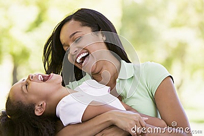 Woman and young girl outdoors embracing Stock Photo