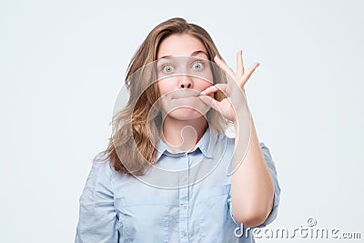 Woman zipping her mouth shut - keeping quiet concept Stock Photo