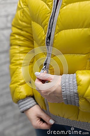woman zips up her warm colored jacket Stock Photo