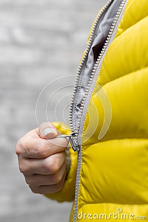 a woman zips up the zipper on her colored jacket with her hand Stock Photo