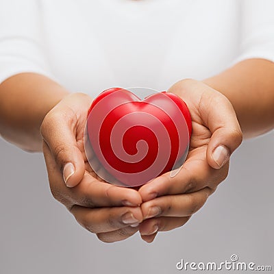 Womans cupped hands showing red heart Stock Photo