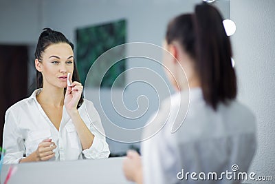 Womem in mirror clean make-up lips Stock Photo