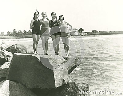 Women in bathing suits posing on rock Stock Photo