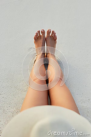 Women Beautiful Sexy Legs on the Beach. Skin care and Protection Sun. Spa Concep. Stock Photo