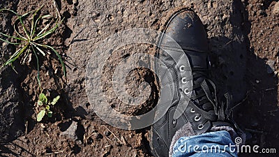 Women boots in the mud, detail of dirty boots and muddy, walk. Top down dirty black laced boots woman in blue jeans Stock Photo