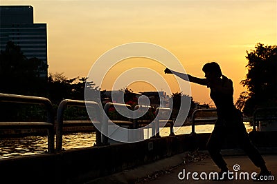 Women boxing exercise and martial arts silhouette on sunset Stock Photo