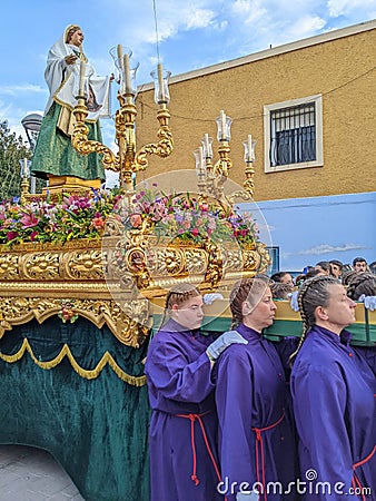 Women carrying float with religious sculpture of Virgin Mary during Holy Week processions in Spain Editorial Stock Photo