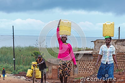 Women carrying water Editorial Stock Photo