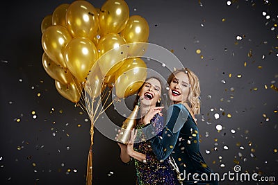 Women celebrating new year among falling confetti Stock Photo