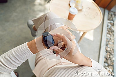 Women checking smartwatch on hand Stock Photo