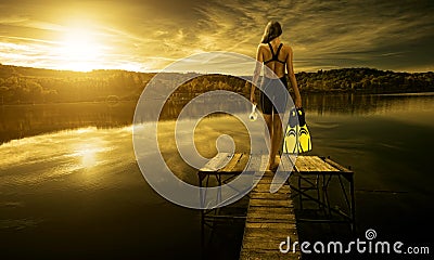 Women diver in swimsuit, on the edge of the pier Stock Photo