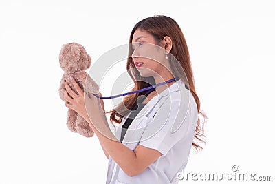 Women doctor uses sthethoscope to detect teddy bear Stock Photo