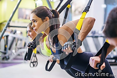 Women doing push ups training arms with trx Stock Photo