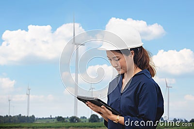 Women engineer using tablet for working on site at wind turbine farm Stock Photo
