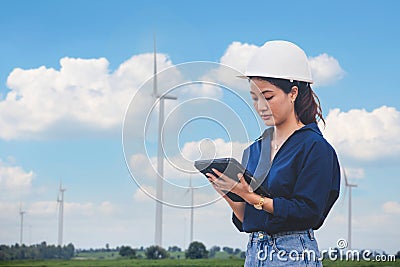 Women engineer using tablet for working on site at wind turbine farm Stock Photo
