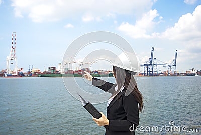 The women engineer working with container Cargo freight ship in shipyard at dusk for Logistic Import Stock Photo