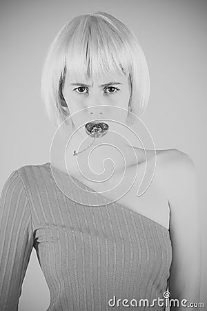 Women face skin care. Portrait women face in your advertisnent. Girl in artificial hair hold red berry in mouth. Stock Photo