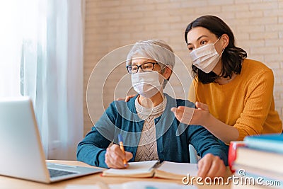 Women in facemasks are using laptop Stock Photo