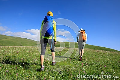 Women friends hiking in grassland mountains Stock Photo