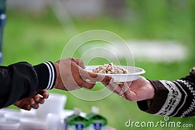 Women hand serving another person a plate with food. Stock Photo