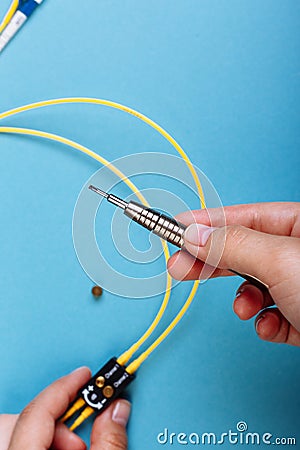 Women Handholds a screwdriver for tuning the optic attenuator. Selective focus. Blue background Stock Photo