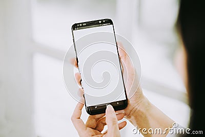 Women hands holding phone with screen on background of window Stock Photo