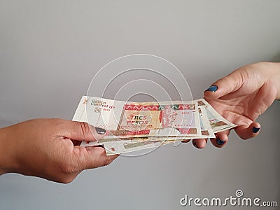 women hands paying and receiving cuban money Stock Photo