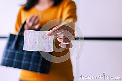 Woman hand putting sanitary napkin in handbag,White menstrual pad,Menses Stock Photo