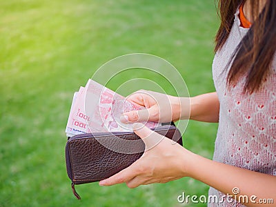 Women Hands taking out money thai baht from wallet Stock Photo