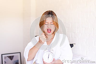 Woman hates getting stressed waking up late 6 o`clock,Alarm clock,Weekend morning Stock Photo